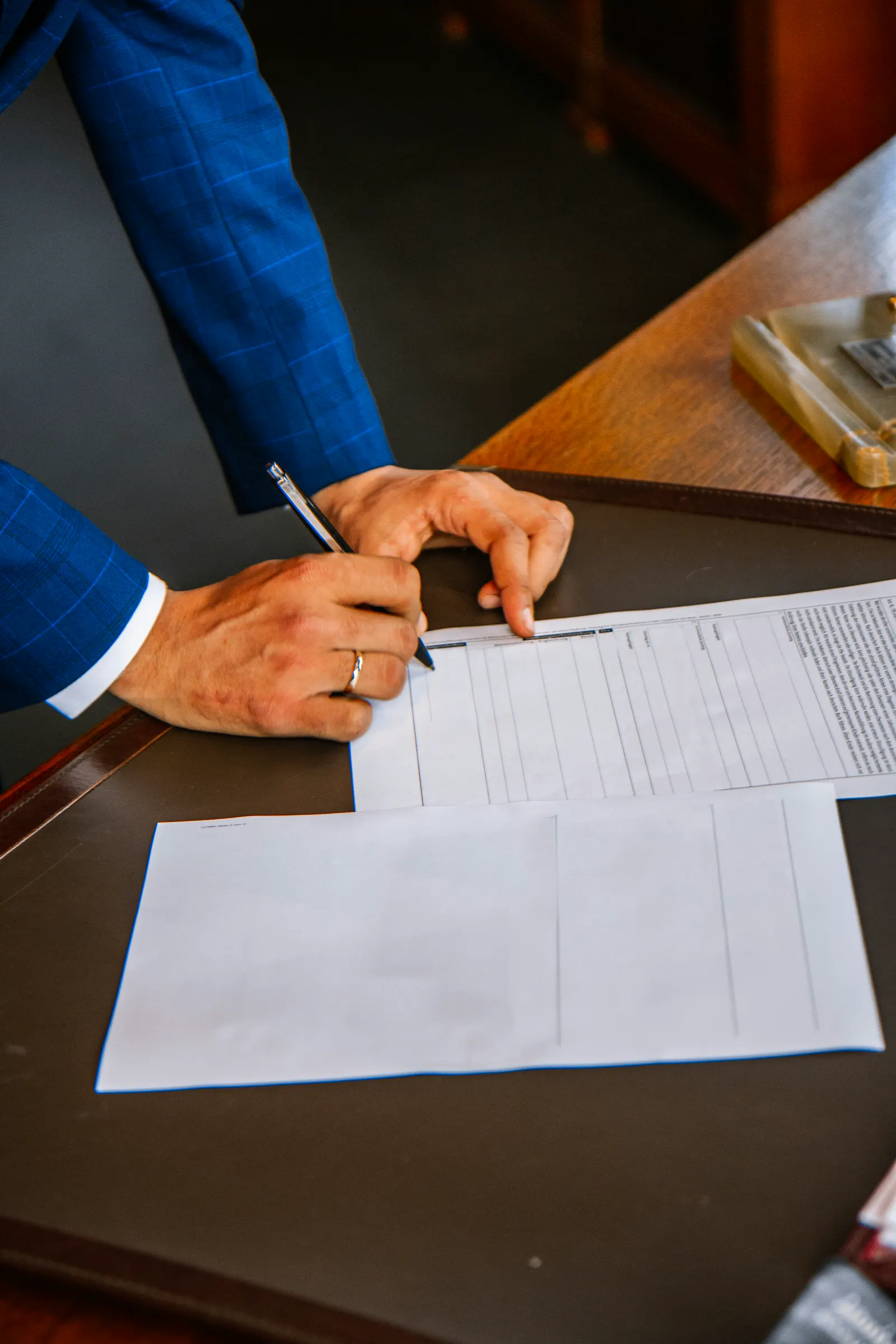 A person signing a contract at a desk.